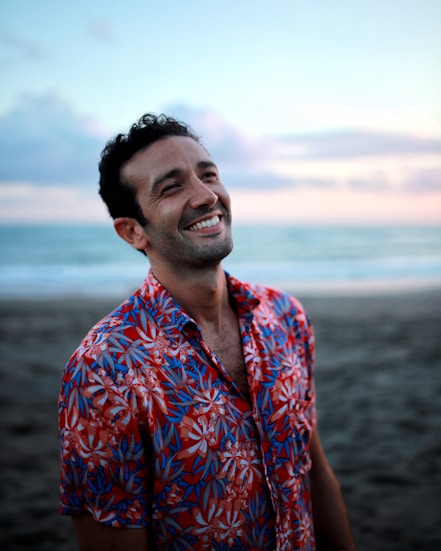 Hombre sonriente en la playa al atardecer
