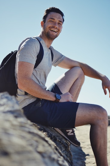 Excursionista sonriente descansando sobre una roca